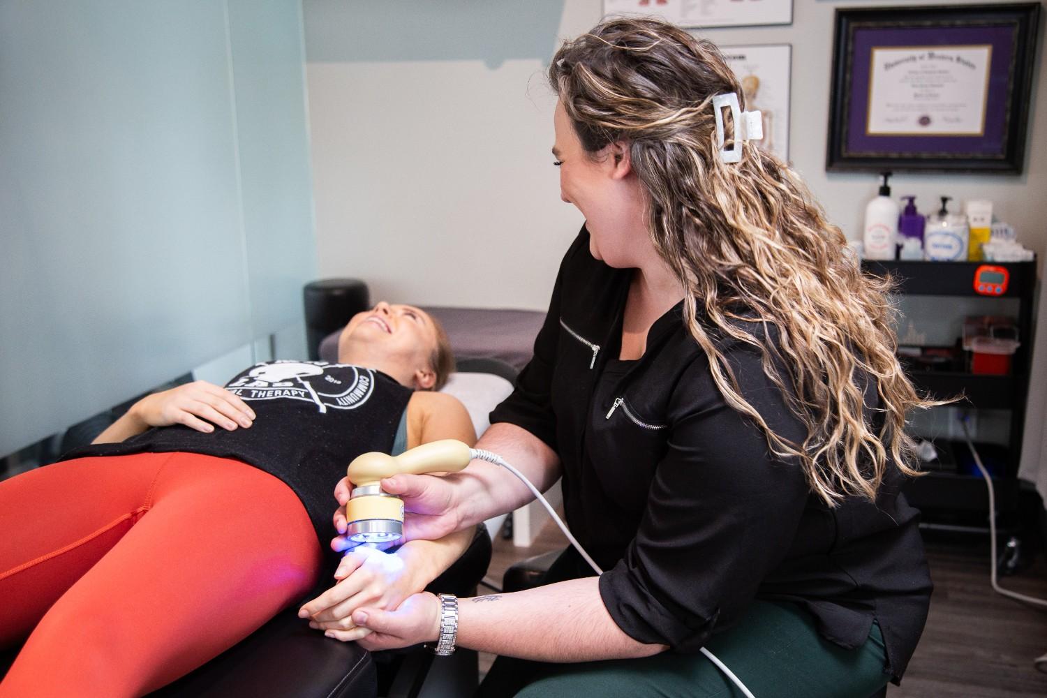 A MYo lab, therapist applying low-level laser therapy to a patient’s hand.