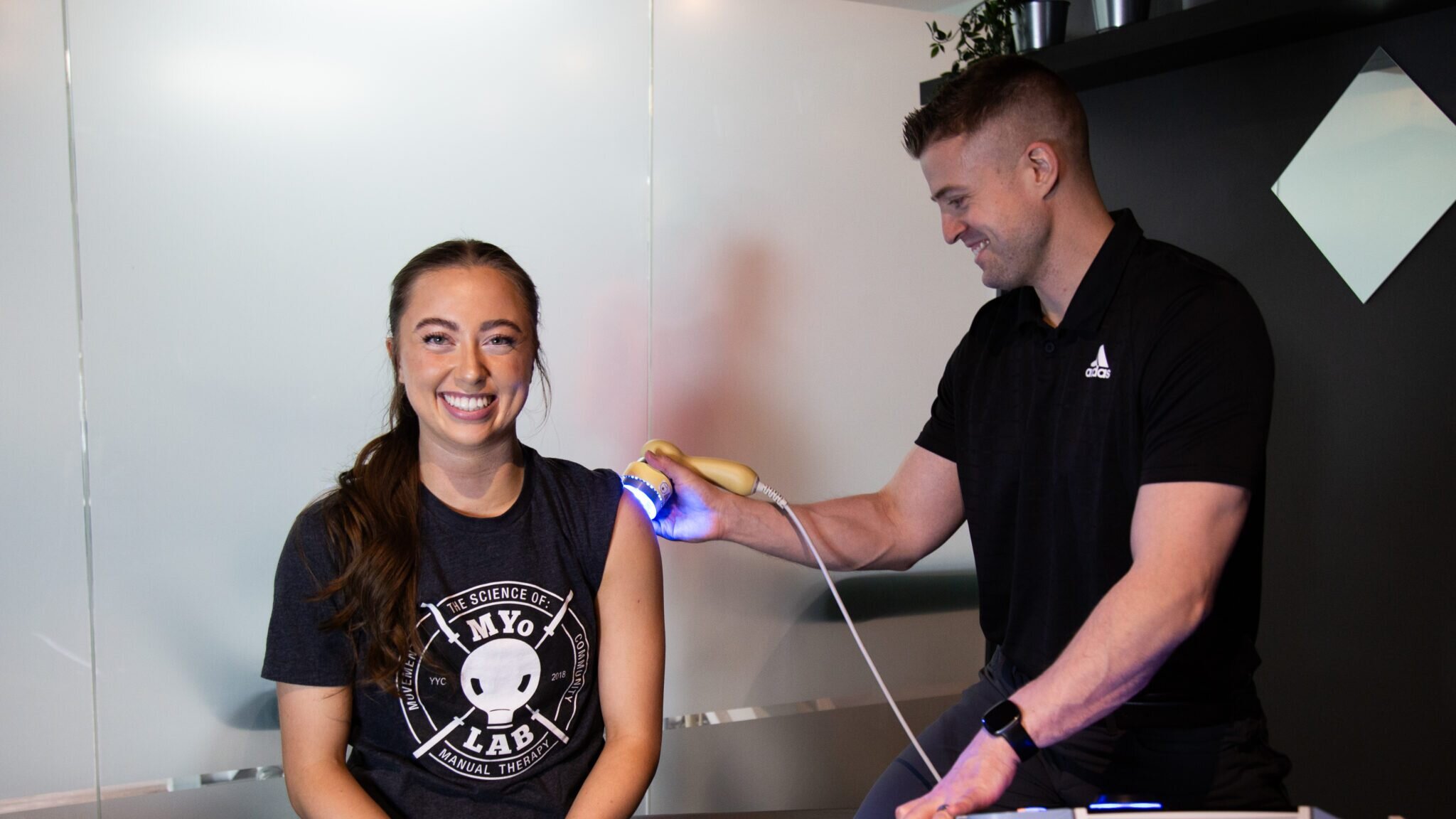 A MYo Lab professional administering Low-Level Laser Therapy (LLLT) on a patient’s shoulder to reduce pain and inflammation.