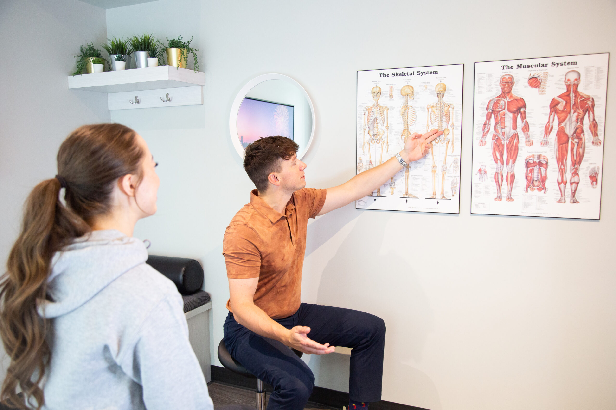 Chiropractor explaining spinal anatomy during a clinical assessment at MYo Lab Health & Wellness in Calgary.
