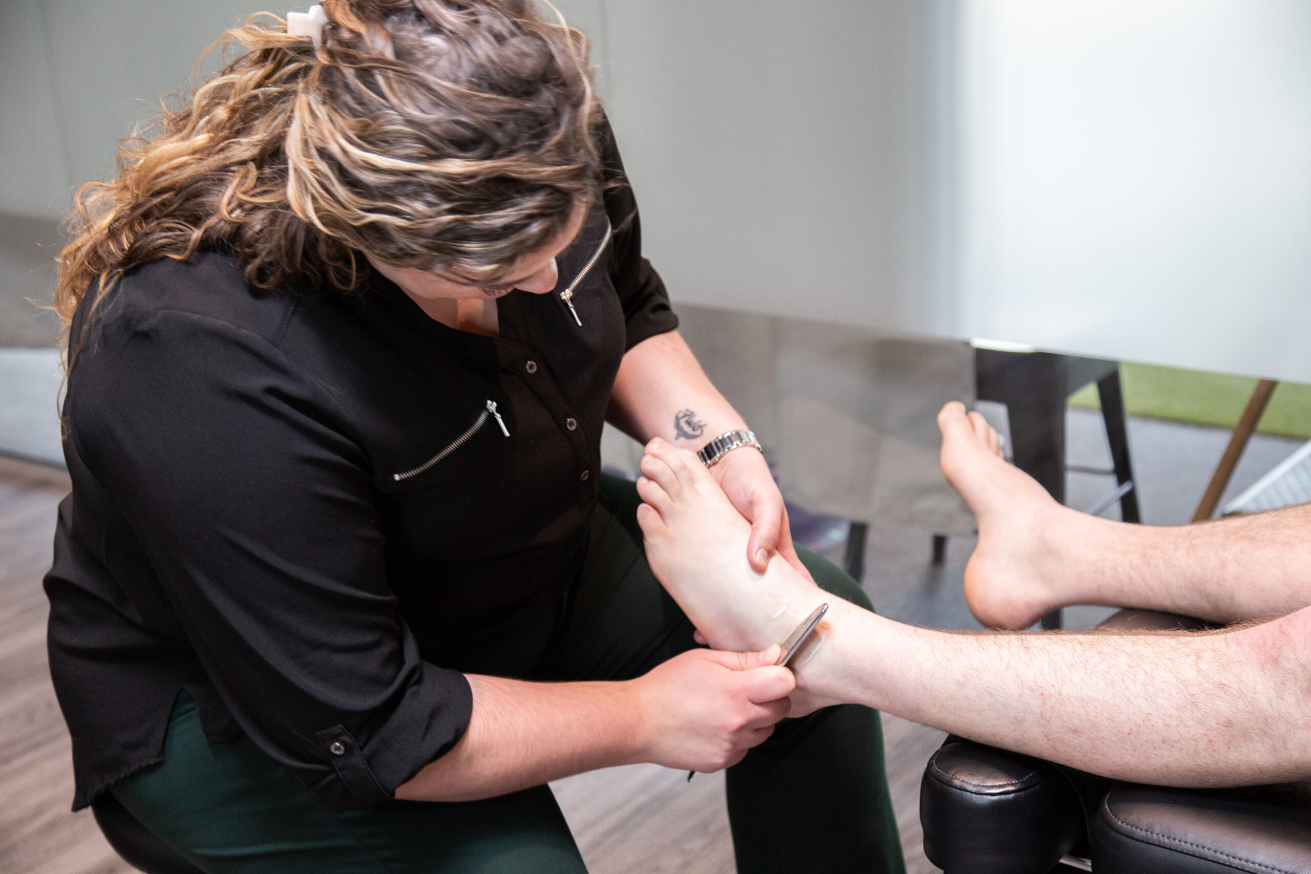 Member receiving ankle graston at MYo Lab Health & Wellness in Calgary, Alberta
