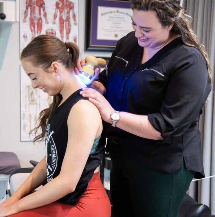 A MYo Lab, therapist applying low-level laser therapy to a member’s neck.