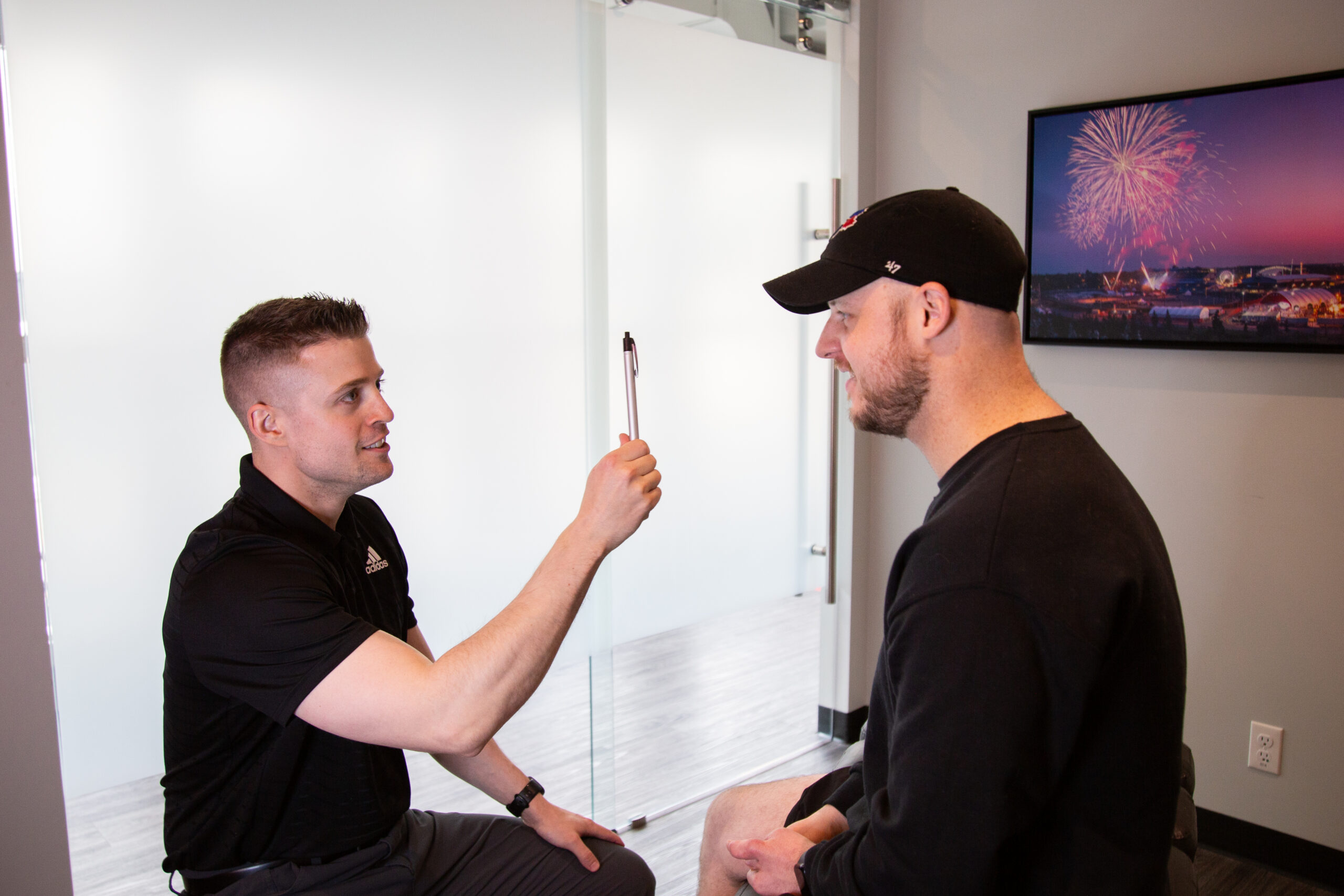 Clinician conducting a finger-tracking neurological test during a concussion assessment at MYo Lab Health & Wellness in Calgary.