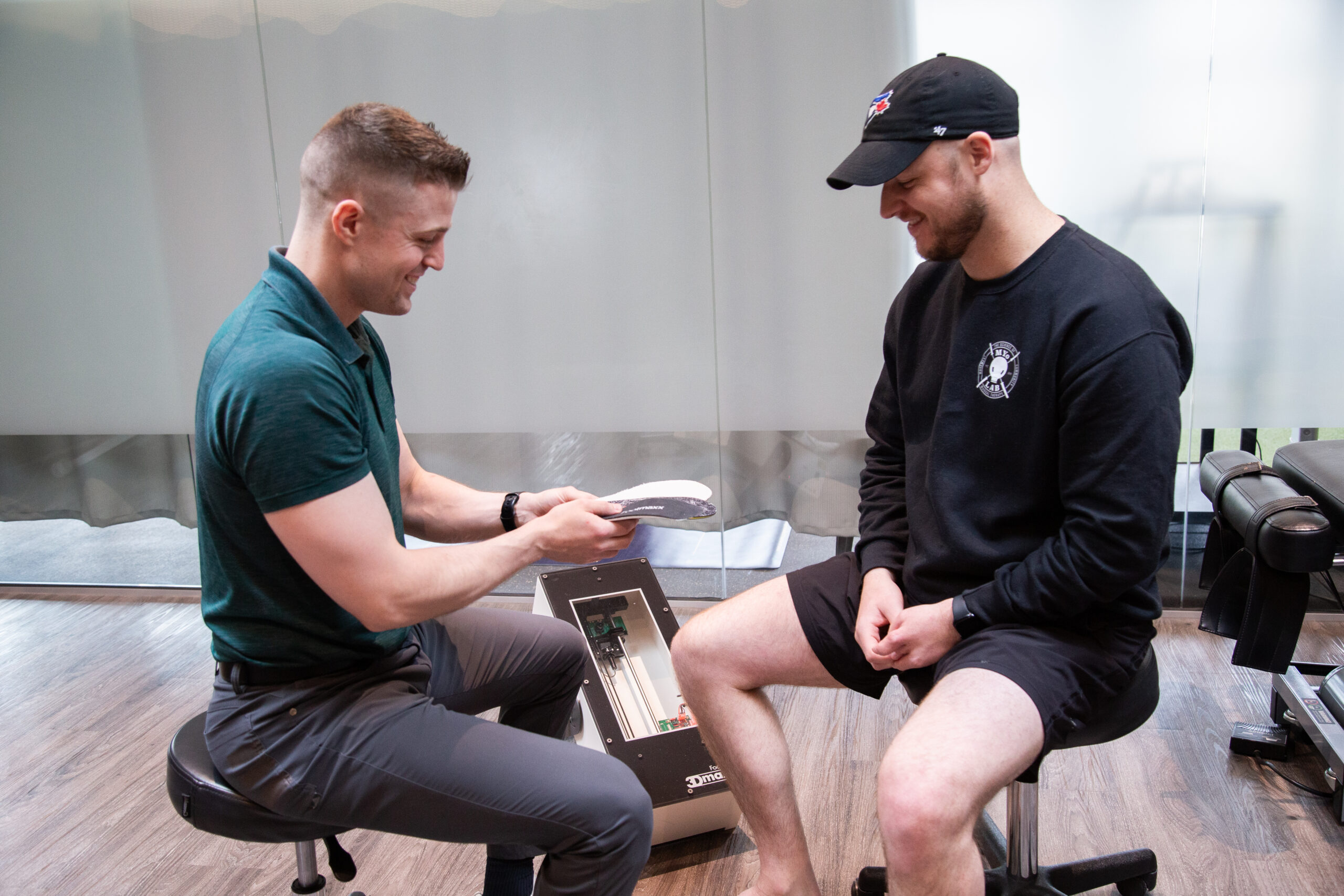 Specialist reviewing custom orthotics to improve foot support, comfort, and movement at MYo Lab Health & Wellness.