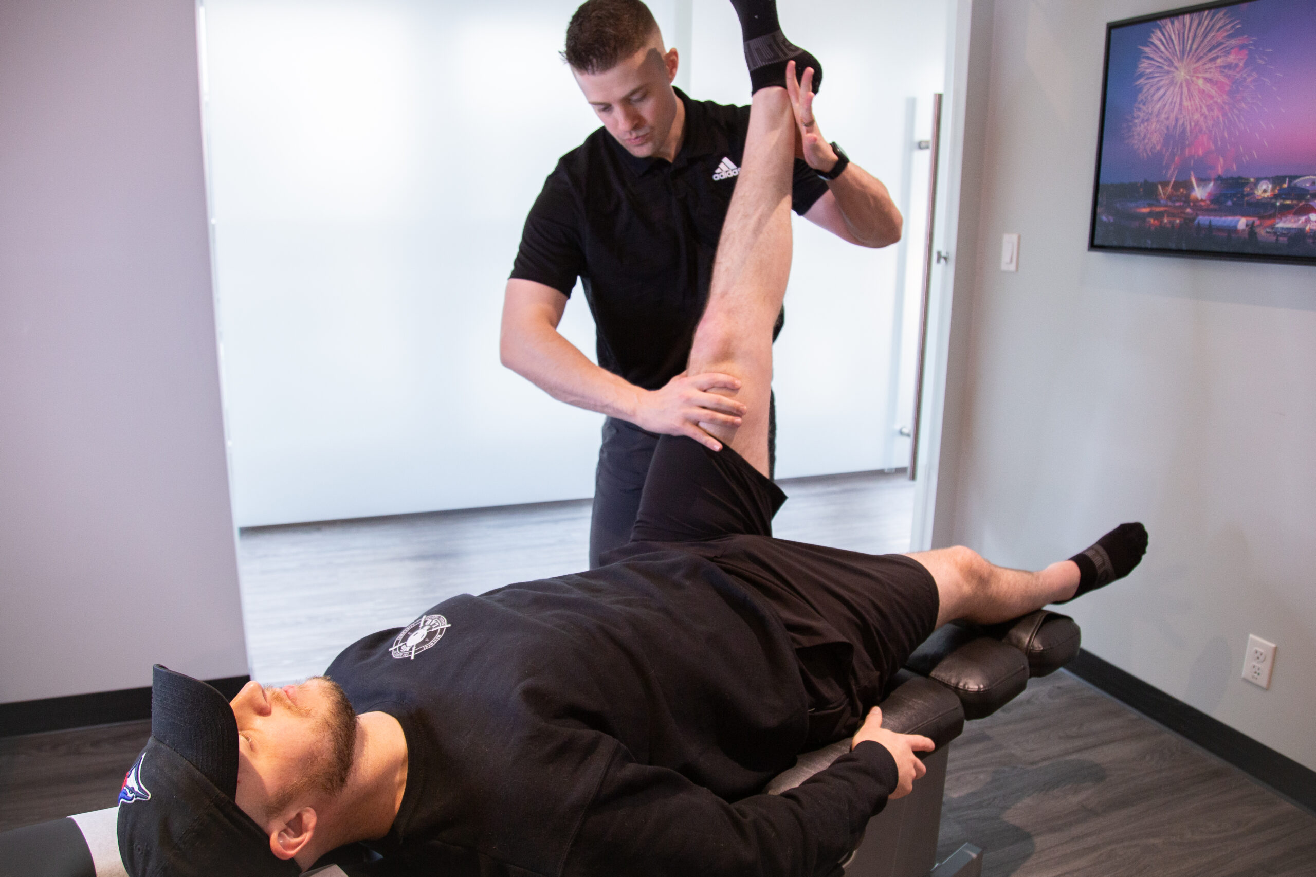 Chiropractor performing a leg mobility test to assess disc herniation symptoms at MYo Lab Health & Wellness in Calgary.
