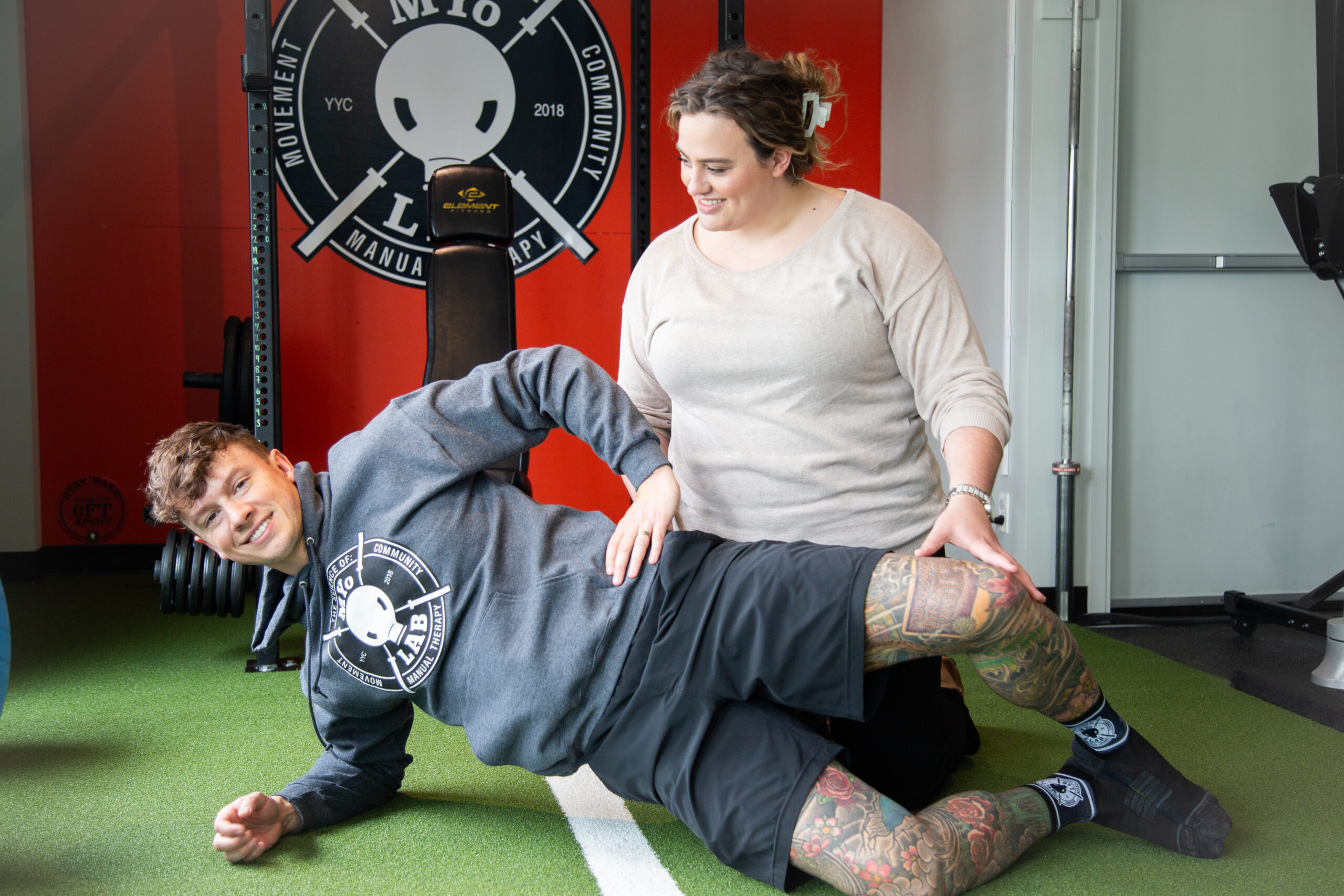Therapist guiding a member through hip pain assessment and corrective exercise to improve mobility, strength, and movement control.