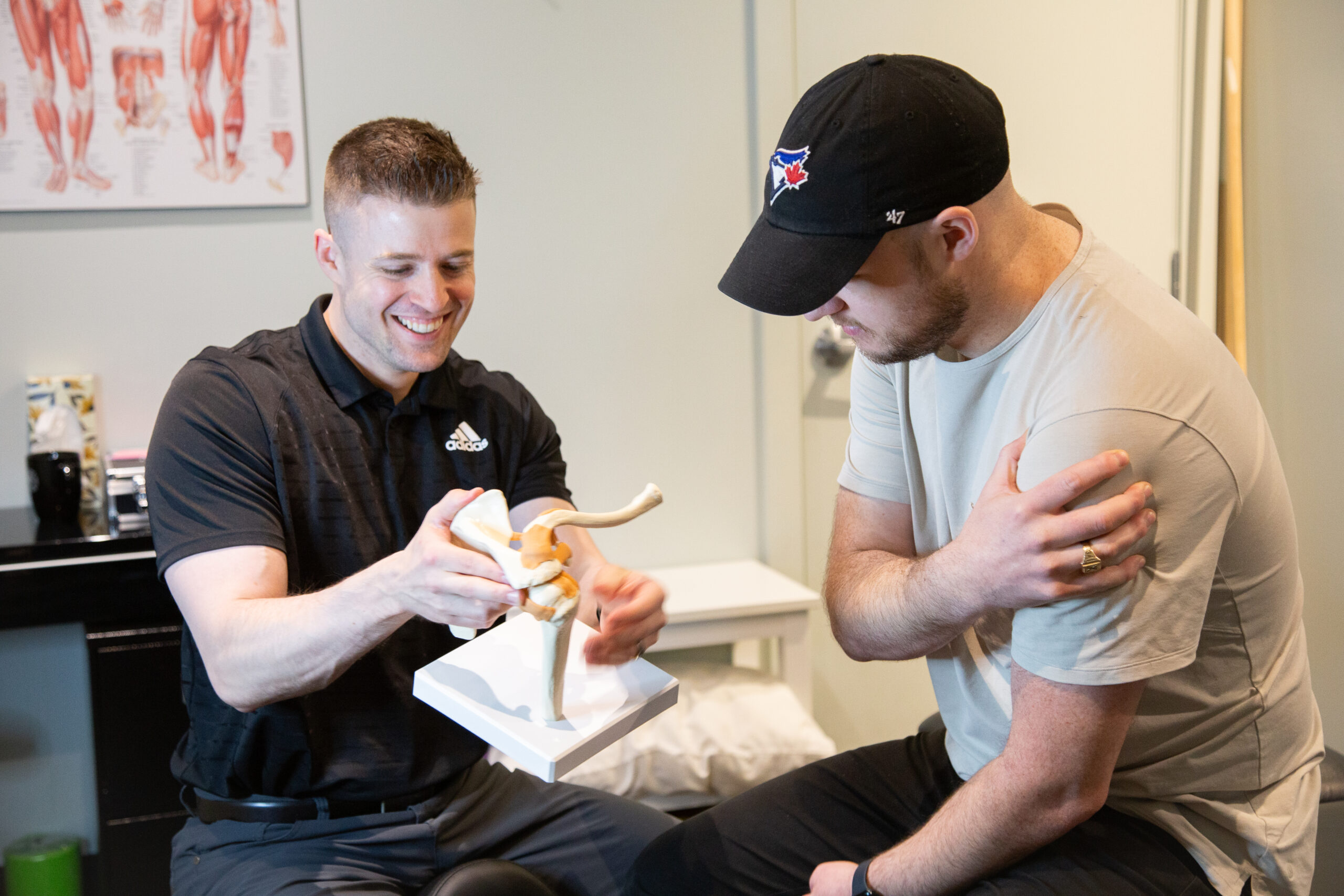 Therapist explaining shoulder joint mechanics during a shoulder pain consultation and treatment.