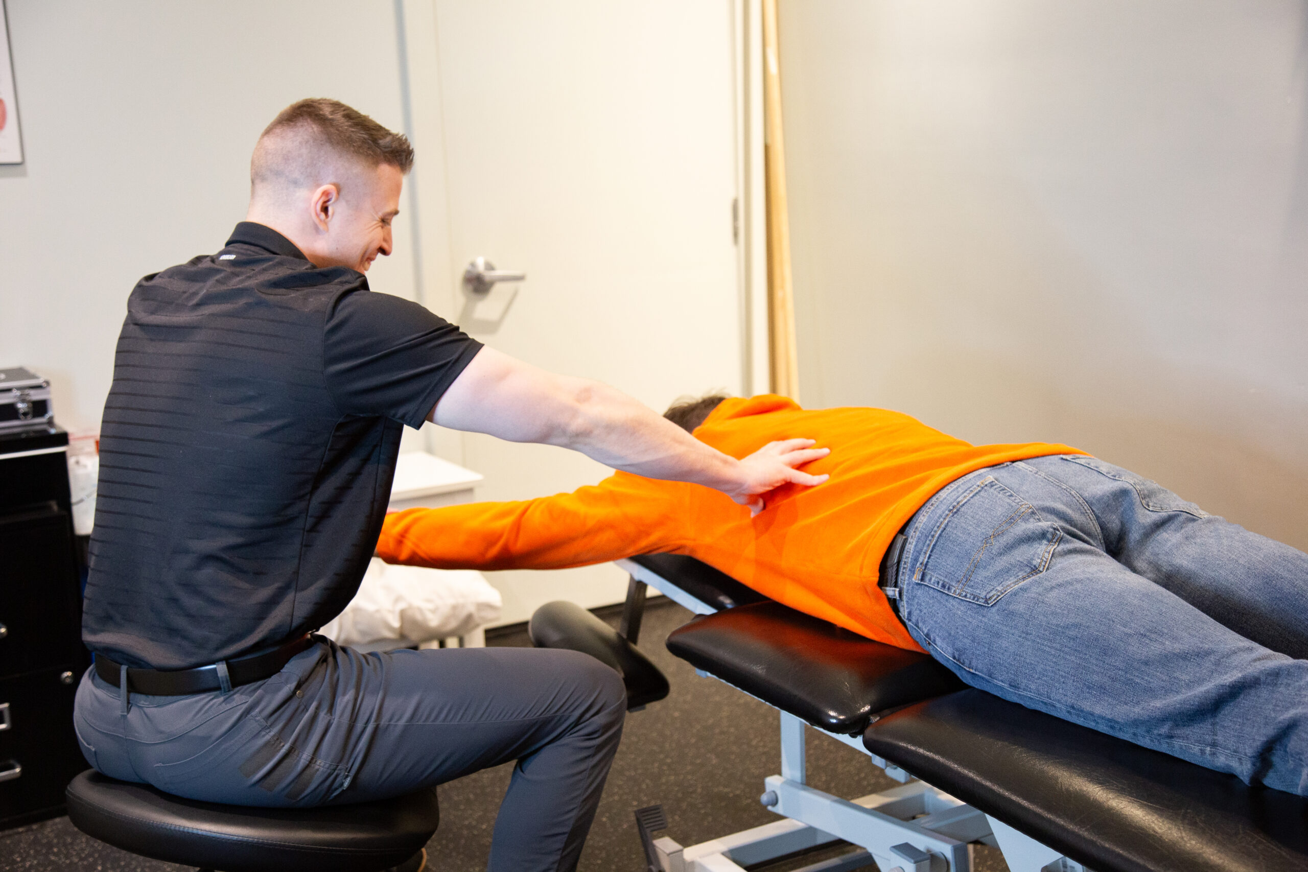 Physical therapist guiding shoulder mobility and stability during a hands-on shoulder pain treatment session.