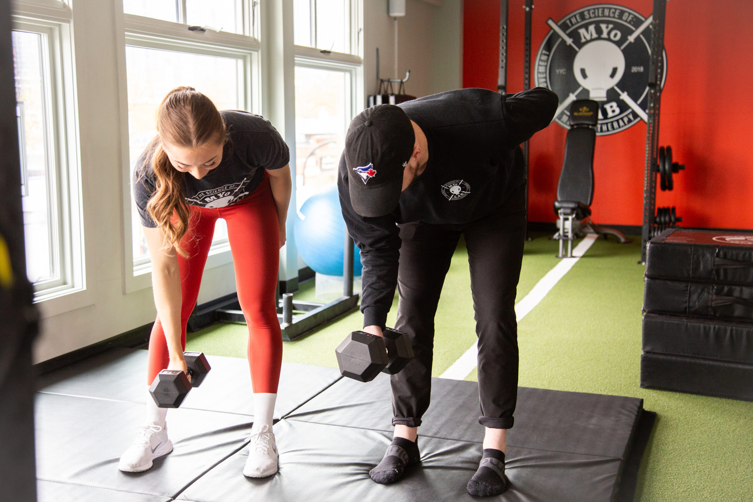 Clients perform dumbbell rows during strength coaching session at MYo Lab Calgary.