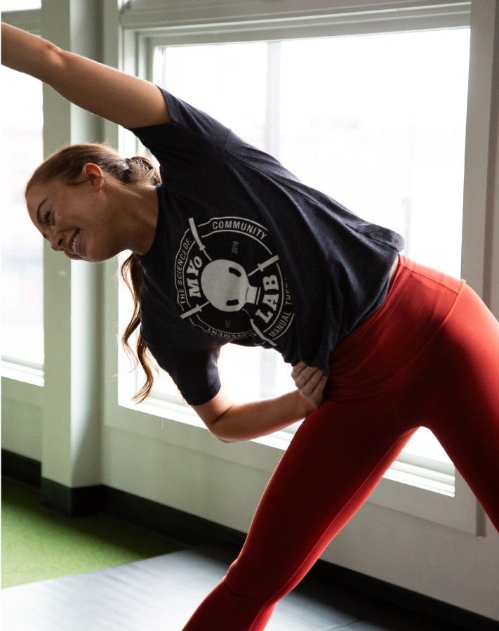 Woman performing a controlled side-bend stability exercise at MYo Lab Calgary, demonstrating strength-focused training for hypermobility management.