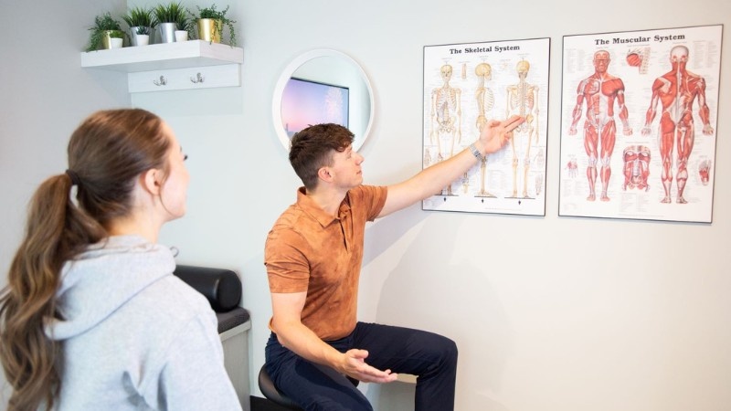 Clinician explaining the muscular and skeletal systems during a chronic pain assessment and rehabilitation consultation.