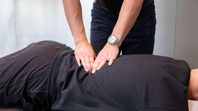 Clinician providing hands-on back treatment to help address stiffness and tension linked to prolonged sitting.